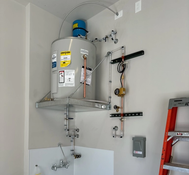 Wall-mounted water heater with connected plumbing and meters.