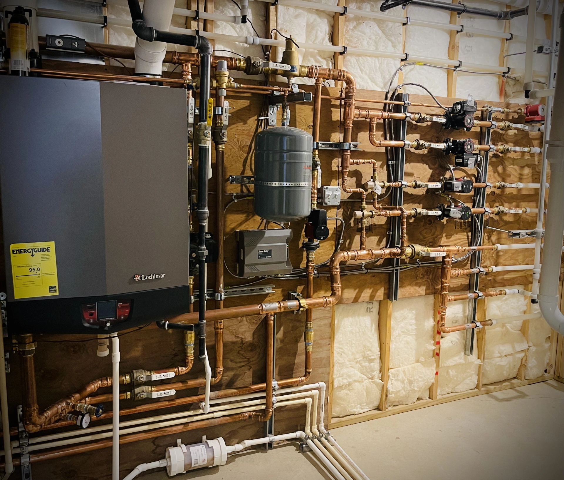 Complex plumbing and heating system setup on a wall.