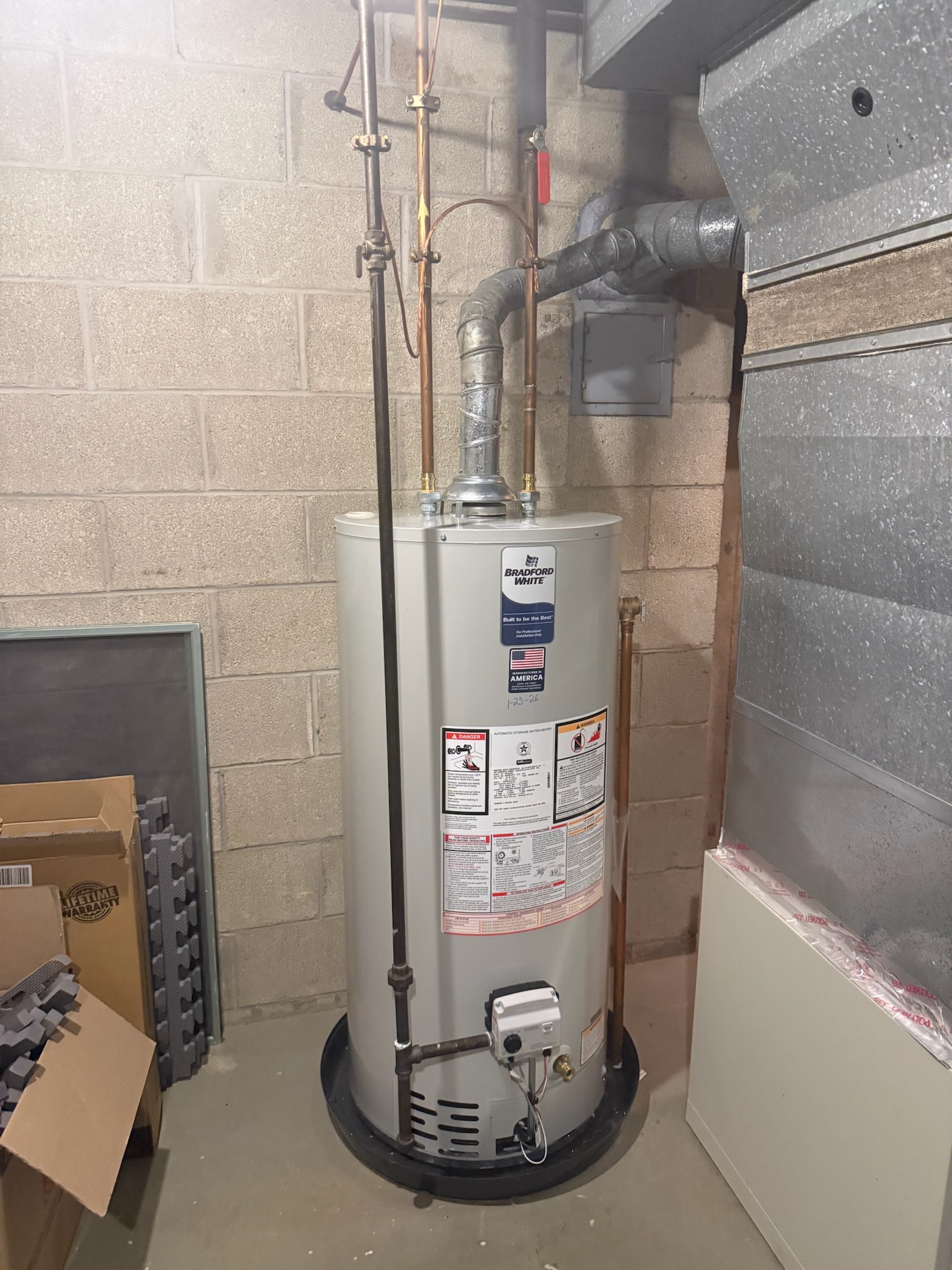 A residential water heater installed in a basement corner.